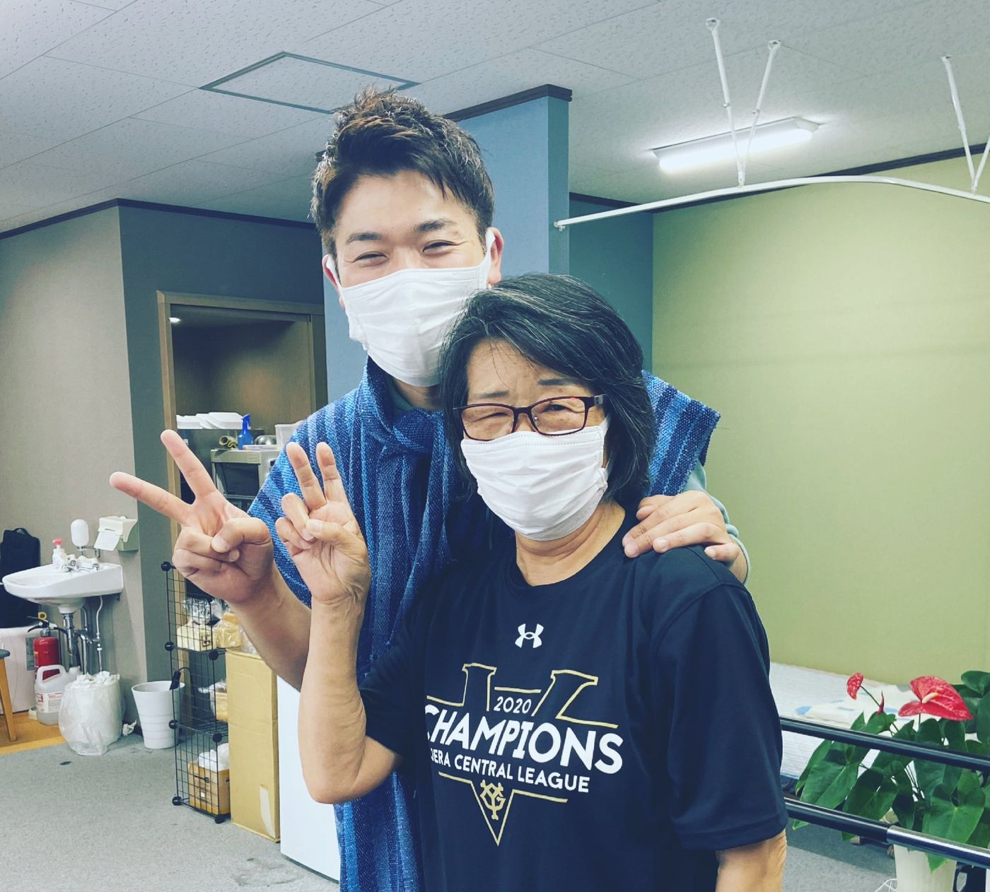 院長と、ご利用者の女性が並んで、笑顔でピースサインをしている写真